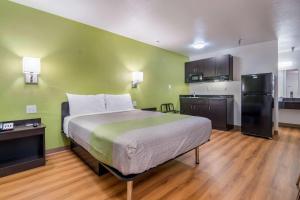a bedroom with a large bed and a kitchen at Motel 6-Abilene, TX in Abilene