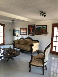 a living room with a couch and a table and chairs at HOTEL BOUTIQUE CASA BLANCA in Chillán