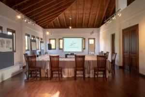 a conference room with a table and chairs and a screen at Hotel Casa Hemingway in Juan Dolio