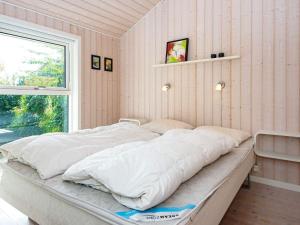 Fjellerup StrandにあるThree-Bedroom Holiday home in Glesborg 28の窓付きの客室の大型ベッド1台分です。
