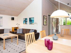 a living room with a table and a couch at Three-Bedroom Holiday home in Glesborg 28 in Fjellerup Strand