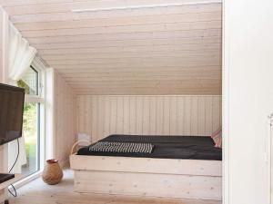 a room with a bed in the corner of a room at Three-Bedroom Holiday home in Glesborg 28 in Fjellerup Strand