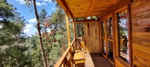 a porch of a cabin with a view of trees at Cabaña en el Bosque de San José del Pacífico 3 in El Pacífico