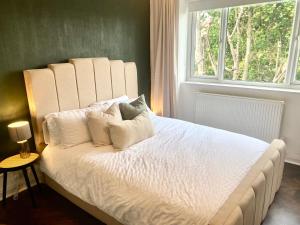 um quarto com uma grande cama branca e uma janela em Newly refurbished 2 BR Apartment in South London em Londres