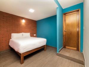 1 dormitorio con cama y pared de ladrillo en Hotel Meson del Barrio en Veracruz