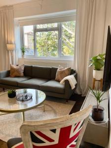 uma sala de estar com um sofá e uma mesa em Newly refurbished 2 BR Apartment in South London em Londres