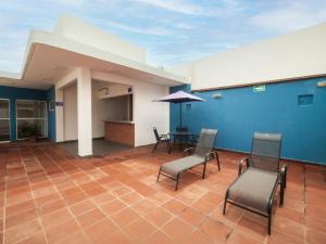 Hotel Meson del Barrio في فيراكروز: غرفة بها كراسي وطاولة والجدار الأزرق