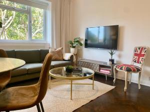 a living room with a couch and a tv at Newly refurbished 2 BR Apartment in South London in London