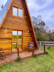 una cabina in legno con sedia su una terrazza di Morada do Corujão - Sossego das Águas a Praia Grande