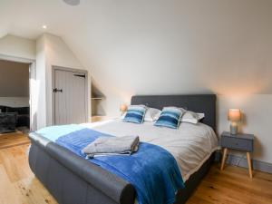 um quarto com uma cama grande e almofadas azuis em The Cart Lodge em Ipswich