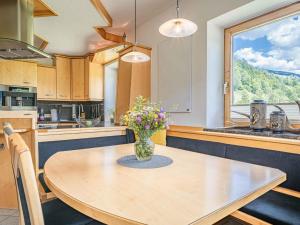 a kitchen with a table with a vase of flowers on it at Gebirgsjagd in Stuhlfelden