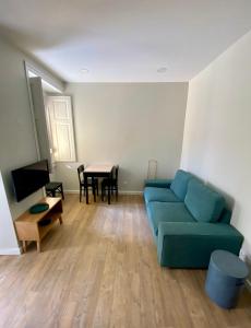 een woonkamer met een blauwe bank en een tafel bij Canarios Apartments Cardal - I in Lissabon