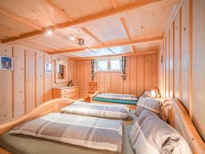 two beds in a room with wooden walls at Chalet Josef in Westendorf