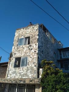 un edificio de piedra con dos ventanas laterales en Kit net Carlotta Apartmentos, en Salvador