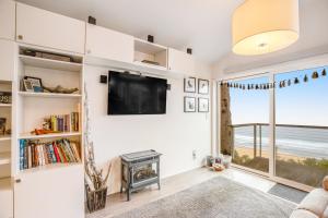 a living room with a flat screen tv and a fireplace at CrowsNest in Oceanside +25 photos