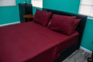 a bed with red sheets and pillows in a room at Glasgow Villa at La Mar in Laborie