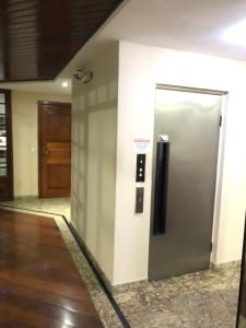 um elevador num edifício de escritórios com uma porta em Apartamento pé na areia - Praia do Forte em Cabo Frio
