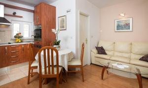 eine Küche und ein Wohnzimmer mit einem Tisch und einem Sofa in der Unterkunft Seaside house for families with children Sutivan, Brac - 20131 in Sutivan + 13 Fotos