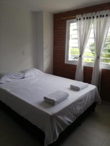 a bedroom with a bed with two towels on it at Hermoso apartamento nuevo primer piso in San Gil