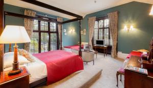 a bedroom with two beds and a desk at Badger Bar in Ambleside