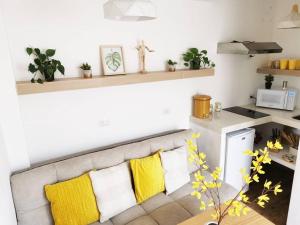 uma sala de estar com um sofá com almofadas amarelas em Immaculate apartment G1 em Guatemala