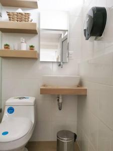 uma casa de banho com um WC branco e um lavatório. em Immaculate apartment G1 em Guatemala