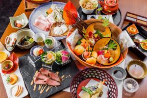 una mesa con muchos platos de comida. en KAMENOI HOTEL Nara en Nara