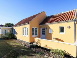 una casa amarilla con una valla delante en 6 person holiday home in Skagen-By Traum, en Skagen