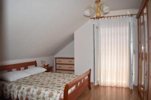 um quarto com uma cama, uma cómoda e uma janela em Kuca za odmor LIBERTA em Pakrac
