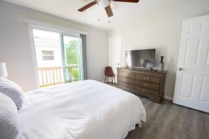 una camera con letto bianco e TV di Relaxing on the bay a Norfolk