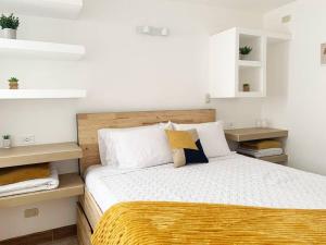 ein Schlafzimmer mit einem Bett mit weißen und gelben Decken in der Unterkunft Great apartment D1 in Guatemala