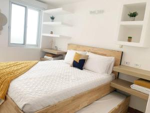 1 dormitorio con 1 cama con sábanas y almohadas blancas en Great apartment D1, en Guatemala