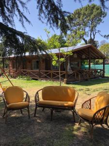 a group of chairs sitting in front of a cabin at EZEIZA quinta cedro azul 10 min del aeropuerto in Ezeiza