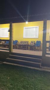 a group of chairs sitting on a porch at night at Chacara em Salto de Pirapora Condomínio Arco Íris in Salto de Pirapora