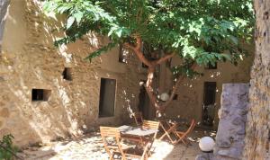 a table and chairs under a tree next to a building at Nueva CASA TAÍNO in Benilloba