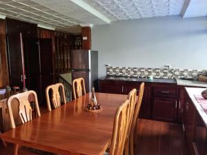 a kitchen with a wooden table and wooden chairs at Villa Azul 
