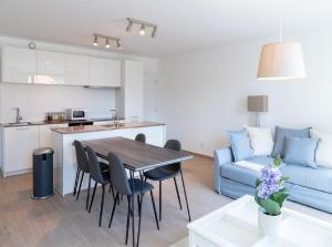 a kitchen and living room with a table and a couch at OneLuxStay near Diamond District in Antwerp