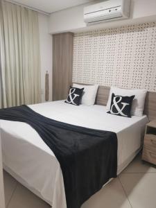 een slaapkamer met een groot bed met zwart-witte kussens bij Landscape VIP Fortaleza in Fortaleza