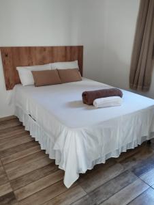 uma grande cama branca com duas toalhas em POUSADA PE NA TERRA EM GUARAREMA em Guararema