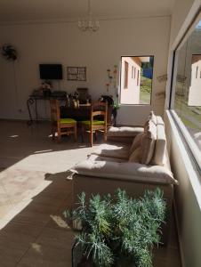 uma sala de estar com um sofá longo e uma mesa em POUSADA PE NA TERRA EM GUARAREMA em Guararema