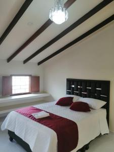 um quarto com uma cama grande e um lustre em Hotel Castillo Real em Popayán