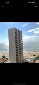 a building on the beach with the ocean in the background at Flat number one temporadalitoranea in São Luís