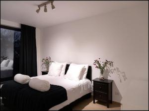 a bedroom with a bed with white sheets and pillows at OneLuxStay near Diamond District in Antwerp