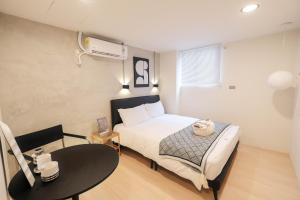 a small room with a bed and a table and a bed sqor at 七七漫旅 Seven77 in Tainan