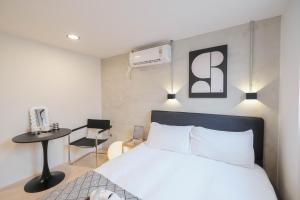 une chambre avec un lit, une table et une chaise dans l'établissement 七七漫旅 Seven77 I 中西區住宿, à Tainan