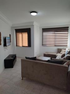 sala de estar con 2 sofás y TV en Tiba soliman plage, en Nabeul