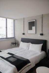 a bedroom with a large bed with a black and white blanket at 七七漫旅 Seven77 in Tainan