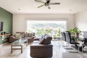 a living room with a couch and chairs and a window at Lindo Condominio Acapulco Dorado Amaras ubicación. in Acapulco