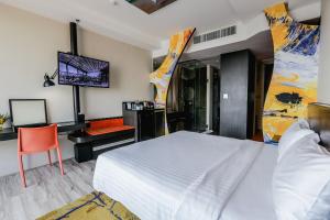 a bedroom with a large white bed and a desk at Siam@Siam Design Hotel Pattaya in Pattaya