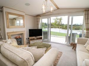 sala de estar con sofá y TV en 10 Cheviot View en Berwick-Upon-Tweed